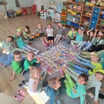 dzieci siedzą w kole i pokazują kolorowe skarpety na swoich stopach 