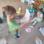 chłopiec szuka kolorowej skarpetki według instrukcji nauczyciela