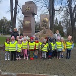 grupa przedszkolna pozuje do zdjęcia pod pomnikiem.jpeg