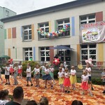 dzieci w kolorowych okularrachch tańczą na scenie.jpg