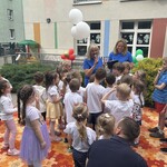 pani stoją z balonami a obok stoją dzieci.jpg