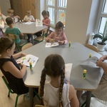 Wiewiórki tworzą prace plastyczne przy stolikach 