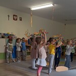 dzieci stoją na dywanie i machają kolorwymi wstążkami.jpg