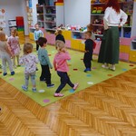 dzieci chodzą po dywanie razem z panią z rudymi włosami.jpg