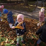 dziewczynka trzyma liść a obok stoją dzieci.jpg