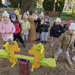 dzieci stoją na placu zabaw obok papierowego worka.jpg