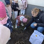 dzieci stoją i patrzą jak nauczycielka robi dziurę w ziemi.jpg