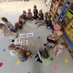 dzieci siedzą na dywanie i oglądają obrazki.jpg