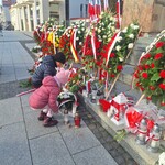 dzieci stawiają znicz pod pomnikiem.jpg