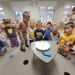 dzieci siedzą na dywanie i obserwują eksperyment.jpg
