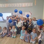 dzieci stoją w sali i trzymają niebieskie balony.jpg