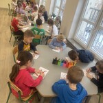 dzieci siedzą przy stolikach i kolorują.jpg