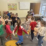 dzieci idą w kole trzymając pluszowe misie.jpg