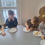 Dzieci jedzą wykonaną przez siebie pizzę 