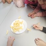 Dzieci próbują jeść chrupki kukurydziane za pomocą pałeczek
