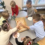 Dzieci robią sami pizzę kładąc składniki na cieście 