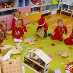 dzieci siedzą na dywanie i rozpakowują prezenty.jpg