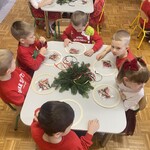 dzieci siedzą przy stolikach na których leżą rzeczy do zrobienia wianków świątecznych.jpg