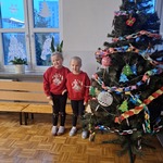 Siostry bliźniaczki stoją przy ubranej choince 