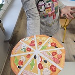 Dziecko trzyma wykonaną z papieru pizzę.jpg