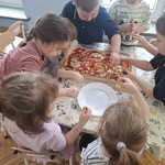 dzieci posypują pizzę serem.jpg