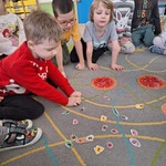 dzieci siedzą na dywanie i elementy pizzy.jpg