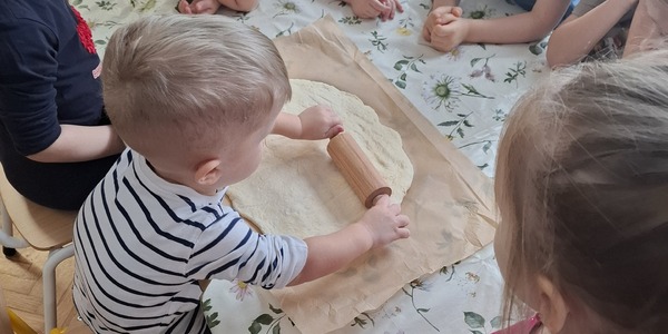 chłopiec wałkuje placek na pizzę.jpg