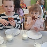 dzieci jedzą pączki które mają w ręku.jpeg