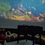dzieci leżą na podłodze i oglądają film z oceanu.jpg