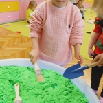 dziewczynka miesza pędzlem zielony piasek.jpg