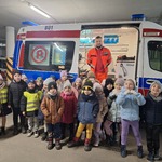 dzieci stoją przed karetka w któej jest ratownik.jpg