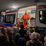 dzieci stoja przy karetce w której stoi ratownik medyczny.jpg