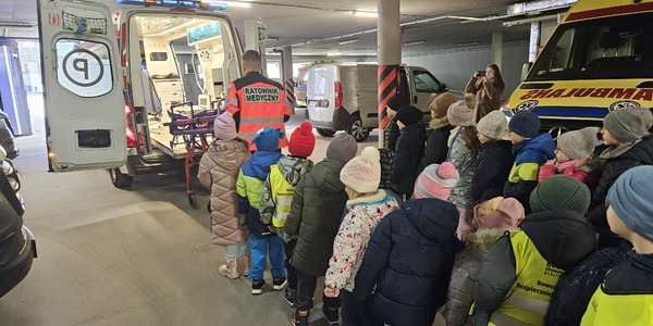 dzieci stoją w kolejce przy samochodzie karetki pogotowia.jpg