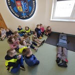 dzieci siedzą na podłodze na której leży manekin.jpg