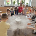 dzieci stoją przy stoliku na którym jest dużo białego dymu.jpg