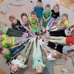 dzieci siedzą w kole i pokazują kolorowe skarpetki.jpg