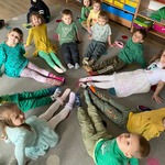 dzieci siedzą na podłodze i pokazują kolorowe skarpetki.jpg