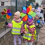 dzieci stoją na chodniku trzymają kolorowe wiatraki.jpg