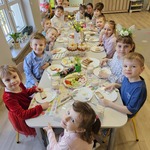 dzieci siedzą przy odświętnym stole wielkanocnym.jpg