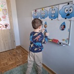 Chłopiec przyczepia do tablicy kartki  z emocjami.jpg