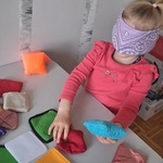 Dziewczynka szuka pary woreczków za pomocą dotyku.jpg