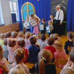 dzieci siedzą i patrzą na aktorów i dzieci stojące na scenie.jpg