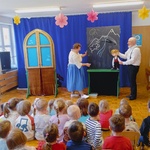 kobieta i mężczyzna stoją na scenie i trzymają maskotkę chłopca.jpg