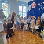dzieci stoją na scenie pani dyrektor przekazuje dziewczynce prezent.jpg