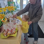 dziewczynka w żółtej koszuli wrzuca pieniądze do puszki.jpg