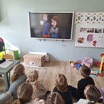 dzieci siedzą na podłodze i oglądają film edukacyjny.jpg