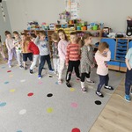 dzieci stoją w rzędzie na dywanie na którym leżą skakanki.jpg