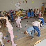 dzieci podają sobie piłki stoją w parach tyłem do siebie.jpg