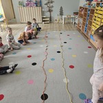 dzieci siedzą na dywanie na którym leża skakanki.jpg