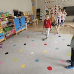 dzieci trzymają czerwony sznurek chłopiec szykuje się do przejścia pod nim.jpg